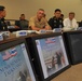 A formal military meeting between U.S. and Thai military officials, identified as 'U.S.-Thailand Senior Staff Talks (SST).' Participants are seated at a conference table with name placards, and multiple monitors in the foreground display the SST title slide featuring both the American and Thai flags. The setting appears to be an official military conference room.