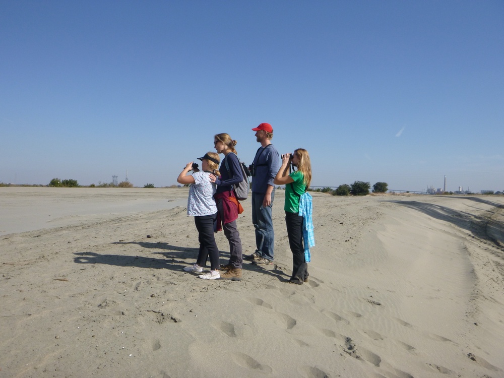 Visitors stand atop newly dredged river sand at the Antioch Dunes National Wildlife Refuge