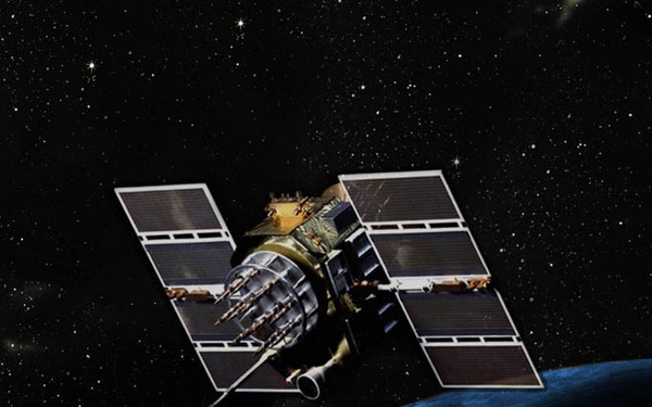 An artist's rendering or composite image of a satellite orbiting Earth, depicted against a star-filled black space background. The satellite features large solar panel arrays and a complex central bus with multiple protruding components. Earth's curved horizon is visible in the lower portion of the image, showing blue atmospheric glow and cloud formations.