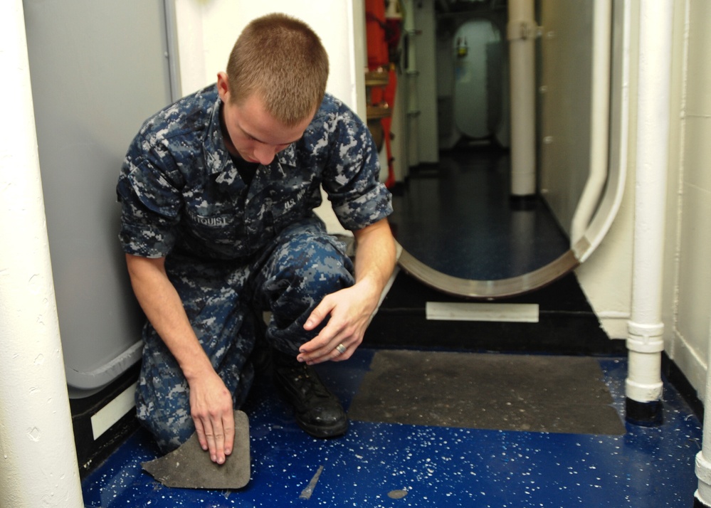 Sailor removes tape from deck
