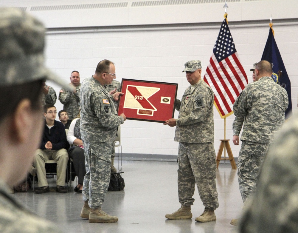 Command Sgt. Maj. Anthony F. Mainiero is presented with a guidon from the 213th Regional Support Group