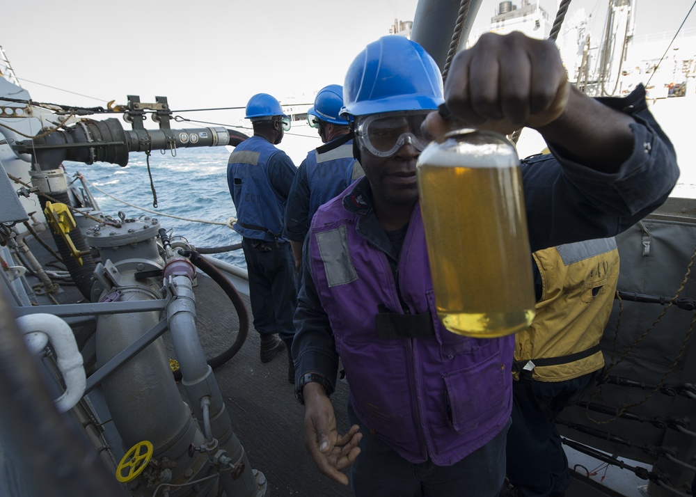 Sailor inspects fuel during replenishment