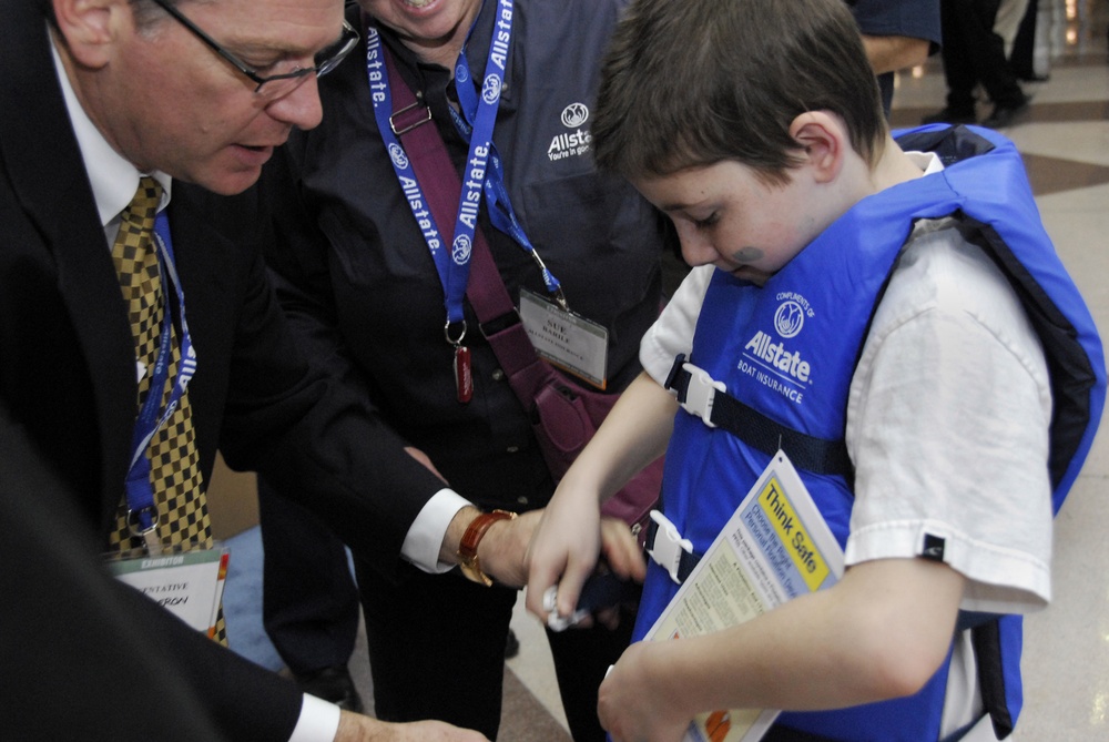 Allstate Insurance representative Jeffrey Calderon helps secure a life jacket
