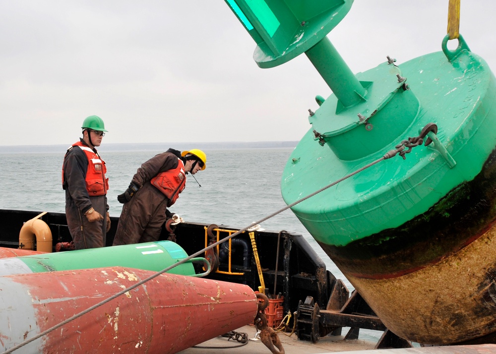 USCGC Buckthorn crew members move buoys