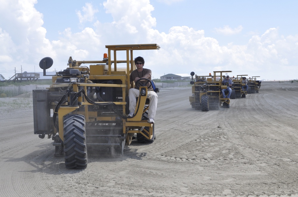 Sand sweeper machines on beach at Grand Isle, La.