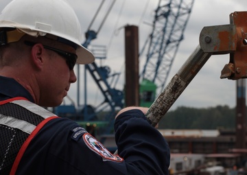 Petty Officer stands watch over flat deck barge Davy Crockett