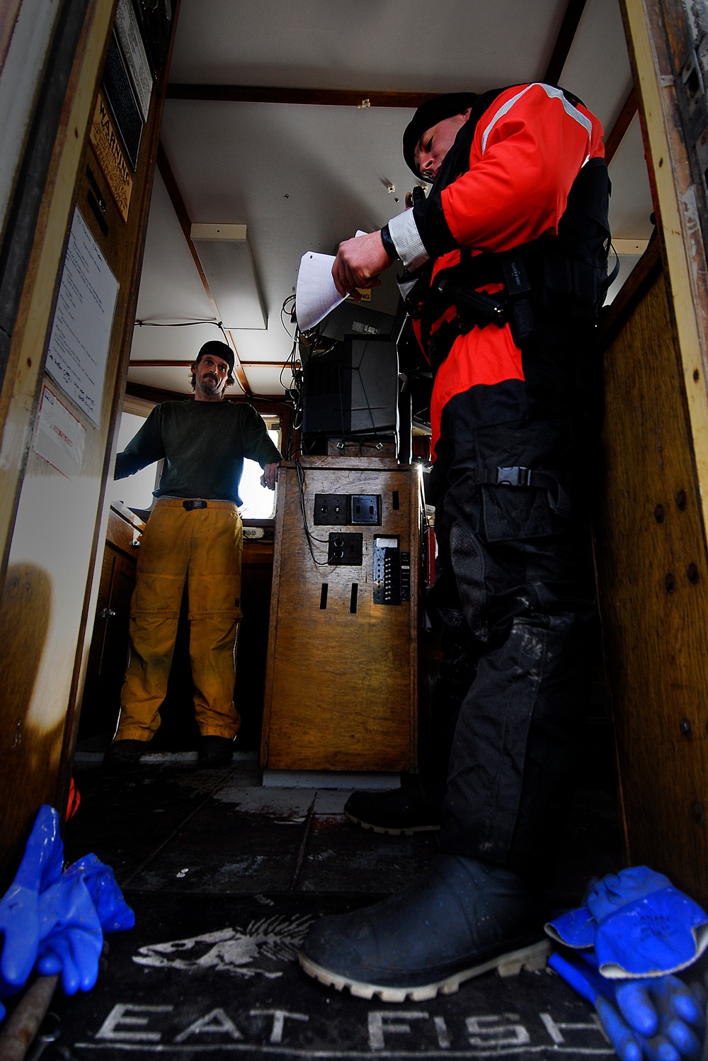 A Coast Guard boarding officer inspects a fishing vessel's documention