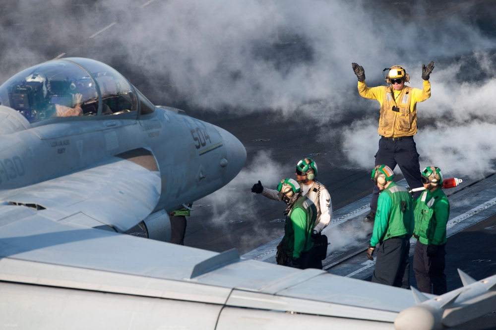 Sailors guide an EA-18G Growler