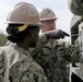 Seabees assigned to NMCB 11 set up and calibrate an Automatic Building Machine.