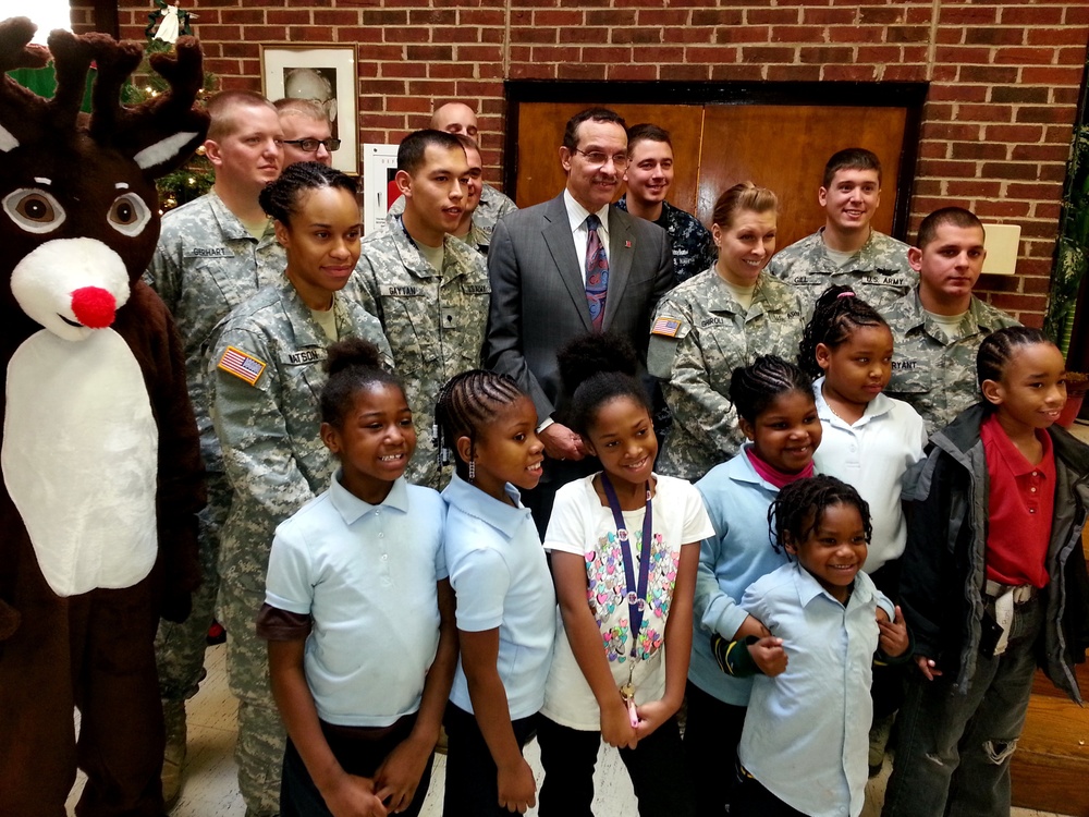 DC Mayor Vincent Gray poses with Rudolph the Red-nosed Reindeer; volunteer military and civilian workers from Joint Base Anacostia-Bolling (JBAB)