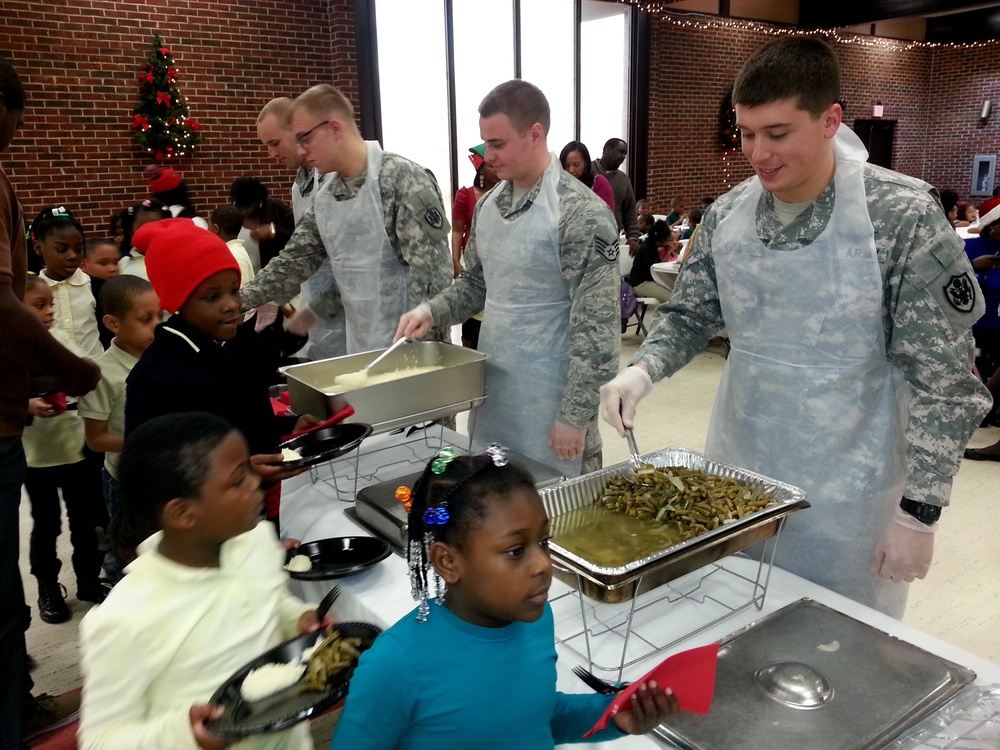 Army and Air Force members from the Joint Base Anacostia-Bolling (JBAB) serve food to youth