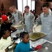 Army and Air Force members from the Joint Base Anacostia-Bolling (JBAB) serve food to youth