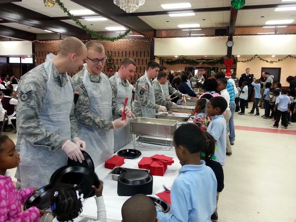 Military members from the Joint Base Anacostia-Bolling (JBAB) prepare to serve food to youth