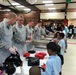 Military members from the Joint Base Anacostia-Bolling (JBAB) prepare to serve food to youth