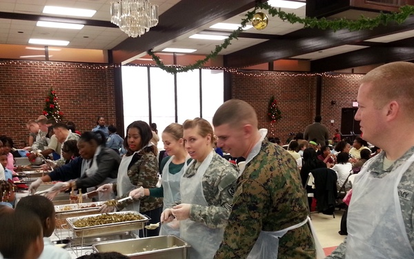 Military members serve food to youth