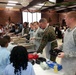 Military members serve food to youth