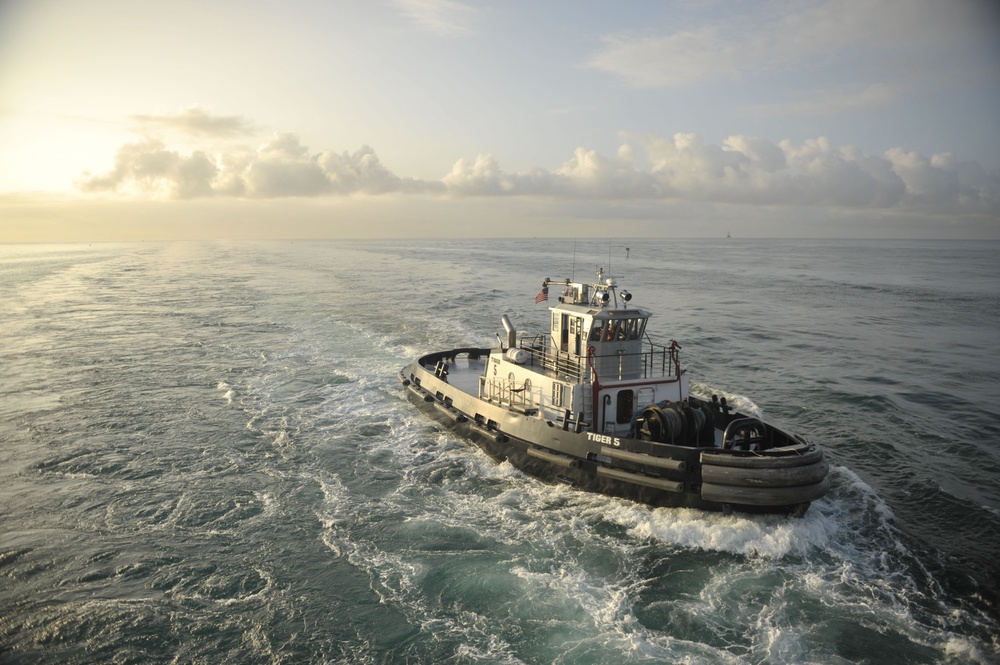 Tugboat escorts USS Nimitz