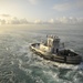 Tugboat escorts USS Nimitz