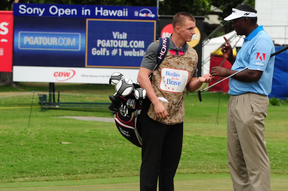 Service members caddy for professional golfers during Pro-Am event