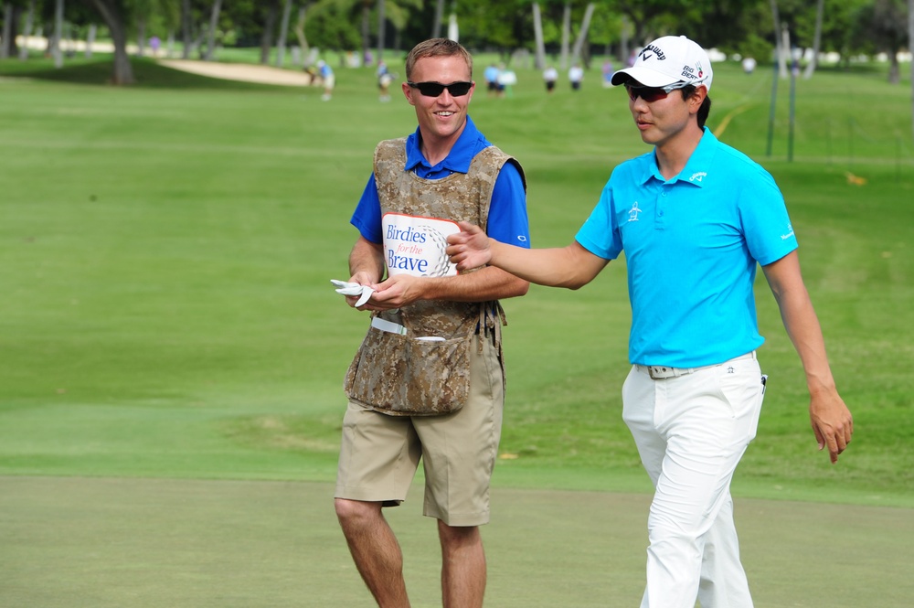 Service members caddy for professional golfers during Pro-Am event