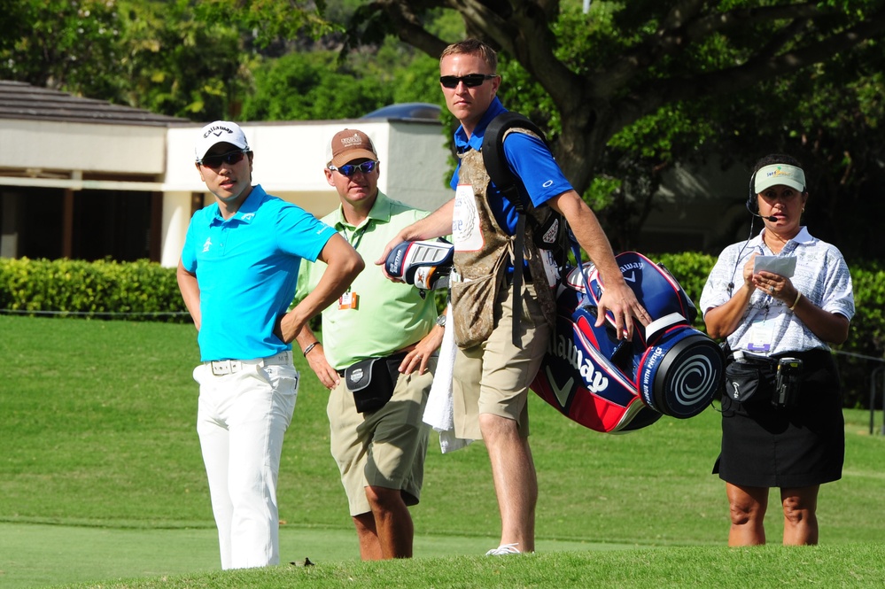 Service members caddy for professional golfers during Pro-Am event