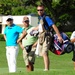 Service members caddy for professional golfers during Pro-Am event