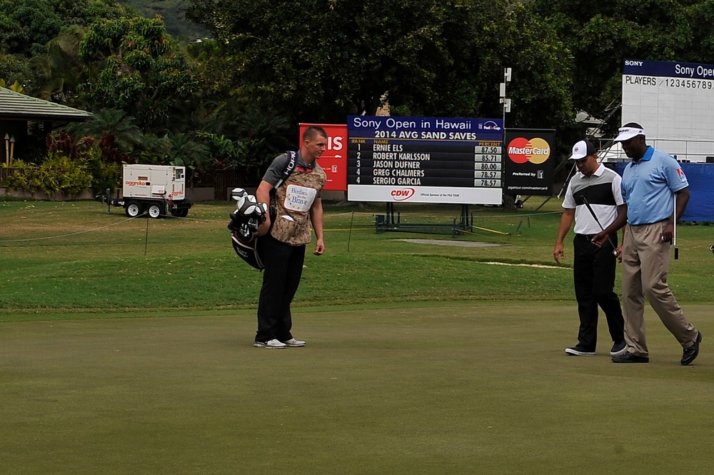 Service members caddy for professional golfers during Pro-Am event