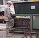 A member of the 249th Engineer Battalion inspects the Primary Switching Center’s generator connections and grounds