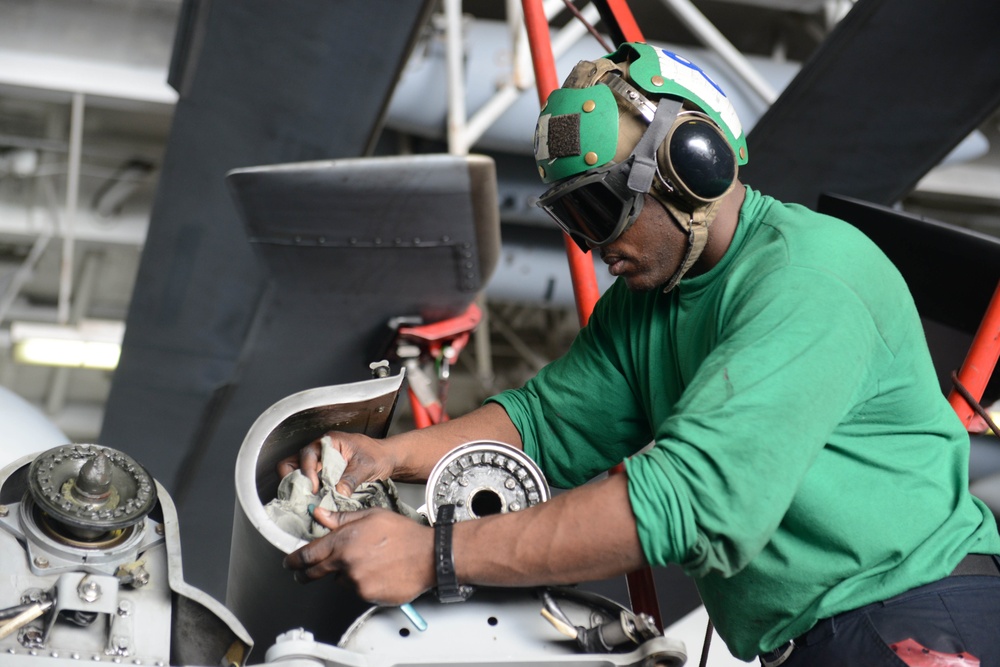 USS Harry S. Truman sailor performs helicopter maintenance