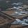 Four A-10 Thunderbolt II (Warthog) aircraft fly in a diagonal echelon formation over a rural landscape. The aircraft display Arkansas Air National Guard markings, with 'FS' tail codes and the Arkansas state insignia visible on the tail fins. The closest aircraft bears 'Fort Smith' nose art, consistent with the 188th Wing based at Fort Smith, Arkansas.