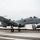 An A-10 Thunderbolt II (Warthog) attack aircraft is captured just above the runway during takeoff or landing at a military airfield. The aircraft bears tail code 'FS 639' and displays Arkansas Air National Guard markings. A second aircraft is partially visible in the background to the right.