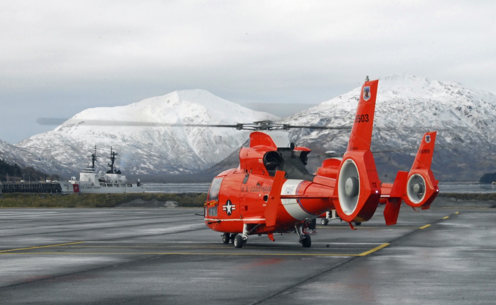 Coast Guard MH-65 Dolphin helicopter crews depart Air Station Kodiak, Alaska