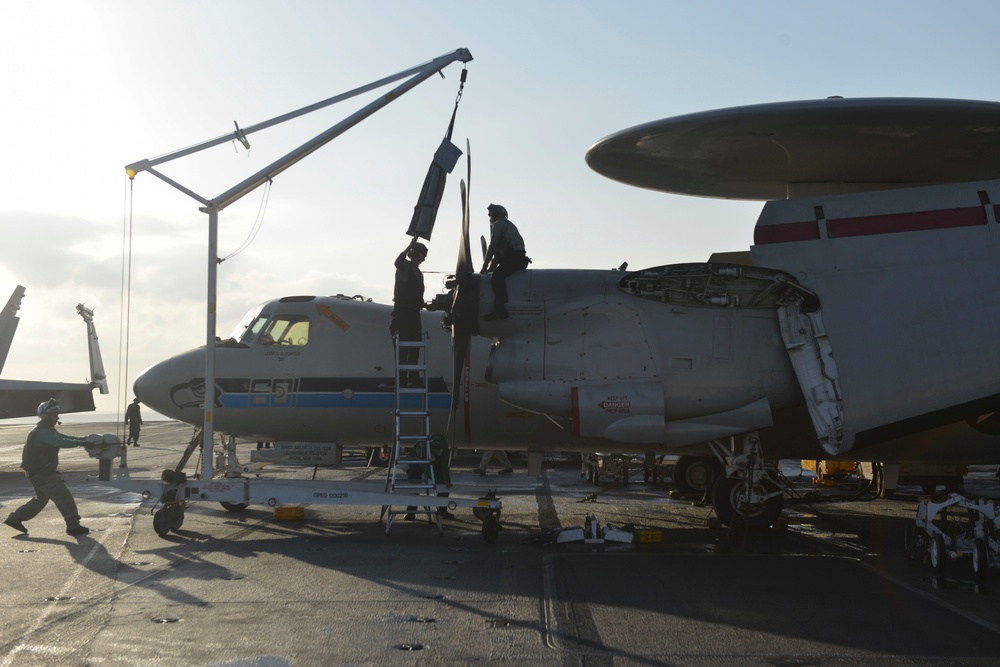 Sailors perform maintenance on an E-2C Hawkeye aircraft