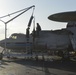 Sailors perform maintenance on an E-2C Hawkeye aircraft