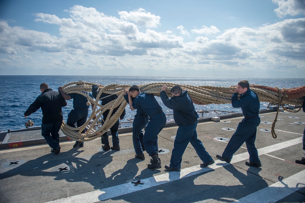 Sailors move a mooring line across the flight deck