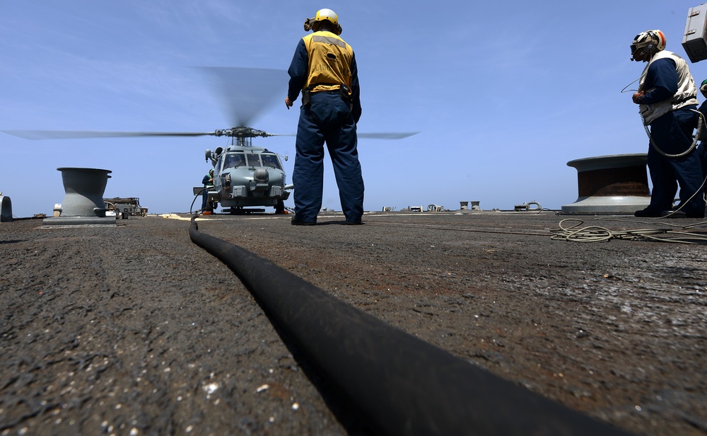 sailors prepare to launch an MH-60R Seahawk