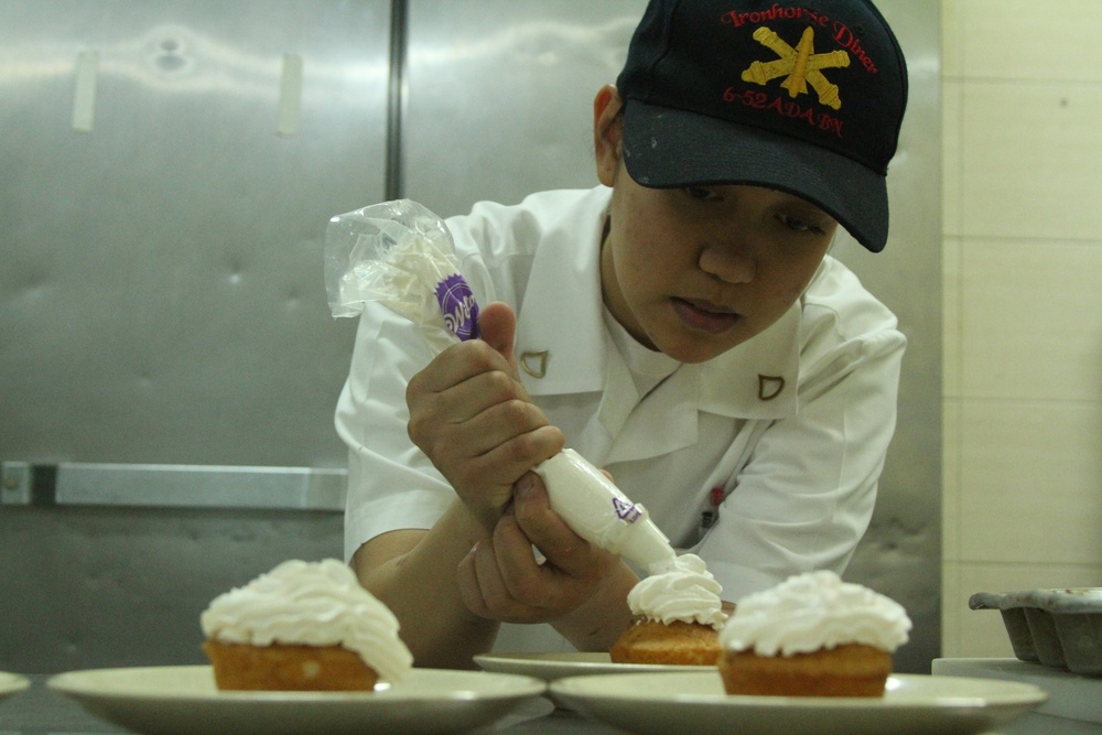 Soldier decorates pastries for troops
