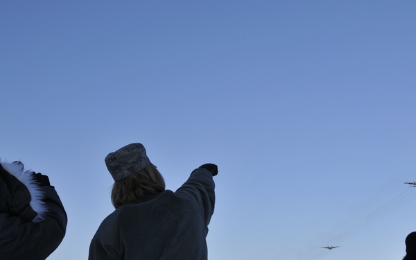 Members watch as aircraft fly over base