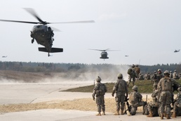 Two U.S. Army UH-60 Black Hawk helicopters land to pick up soldiers