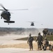 Two U.S. Army UH-60 Black Hawk helicopters land to pick up soldiers