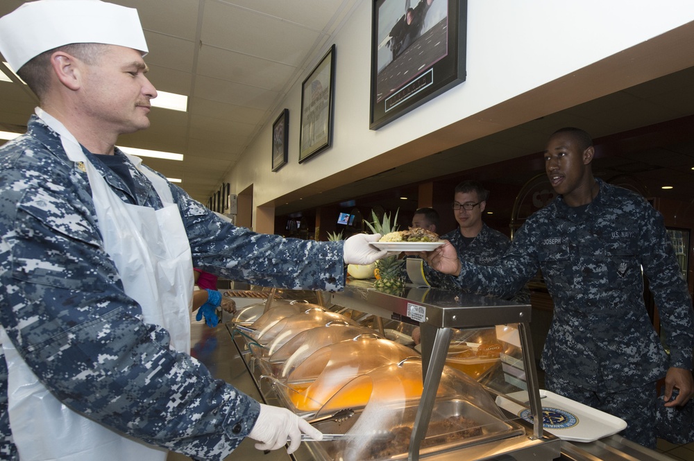 Chief petty officers volunteer their time to serve lunch to sailors at the Naval Station Norfolk base galley