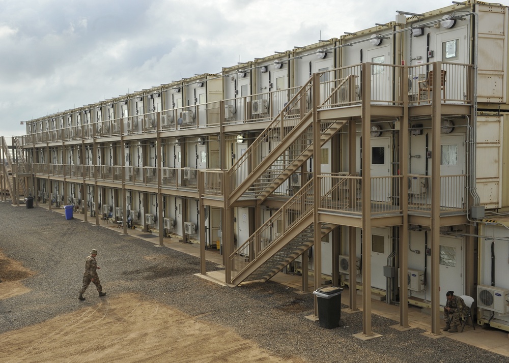 US airman walks towards a housing area composed of containerized living units at Camp Lemonnier, Djibouti, March 27, 2014