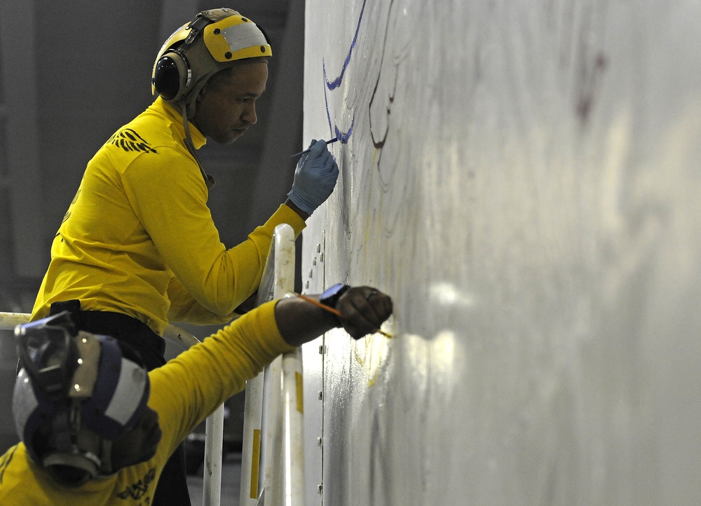 USS Peleliu aviation boatswain's mates paint wings