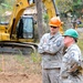 Guatemalan children watch from a nearby tree as Master Sgt. Larry Ricketts discusses construction with First Sgt. Joshua Rich during Beyond the Horizon 2014 on April 8