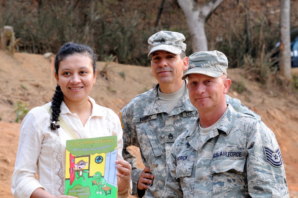 Susana Evangelina Paiz Gonzalez, the school director, smiles after receiving a gift from Tech. Sgt. Riley Kendrick April 17