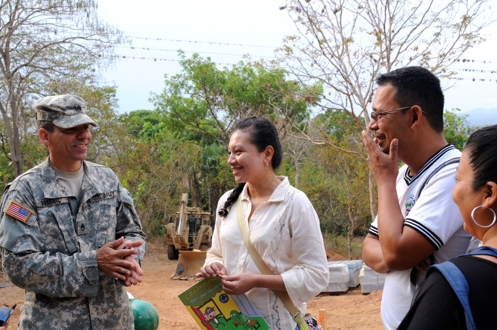 Staff Sgt. Joseph Dominic, a linguist with the 560th Battlefield Surveillance Brigade, Georgia Army National Guard, translates to smiling teachers as they tour the new school site in El Roble April 17