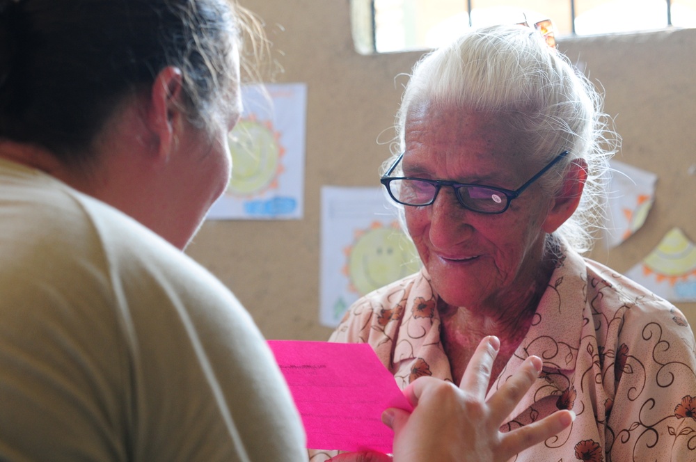 A woman wears glasses for the first time at an optometry clinic during a Medical Readiness Training Exercise at Caseria Los Limones Wednesday, April 23, 2014