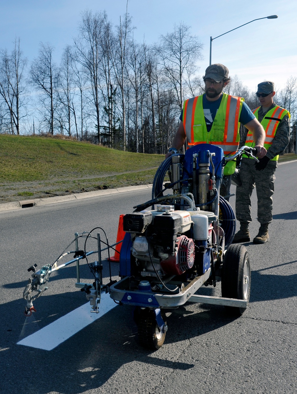 Civil engineers repaint road lines, patch potholes