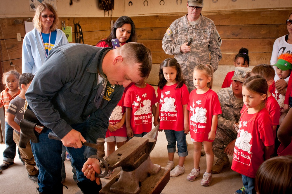 1st Cavalry Division Horse Cavalry Detachment farrier shows school kids how to shoe a horse