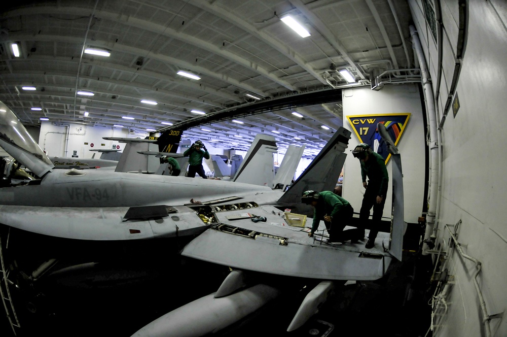 Conducting maintenance on an F/A-18C Hornet